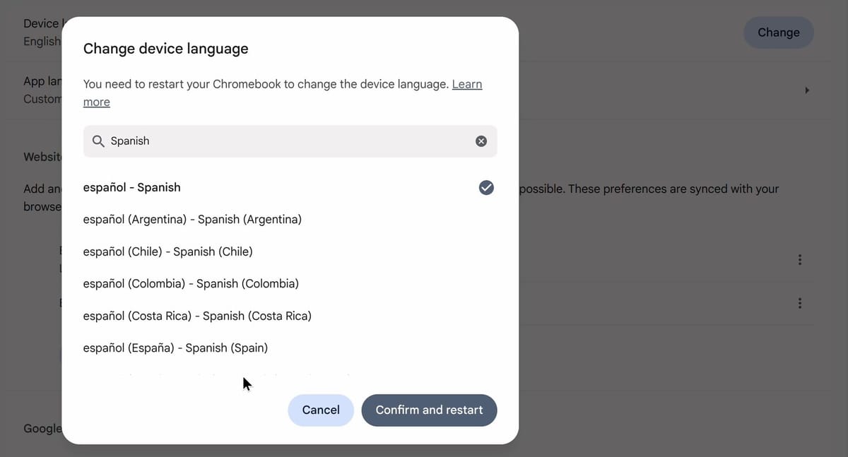 The Change device language dialog with Spanish typed in the search box, the español (Spanish) row checked at the top of the list, and the Cancel and Confirm and restart buttons