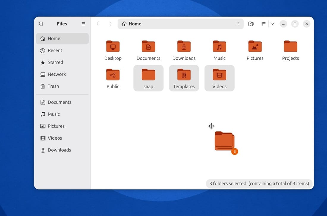 Files in Ubuntu 26.10 with three folders selected and a stacked folder icon under the pointer carrying an orange badge with the number 3